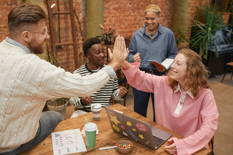 group-young-people-high-five-across-meeting-table