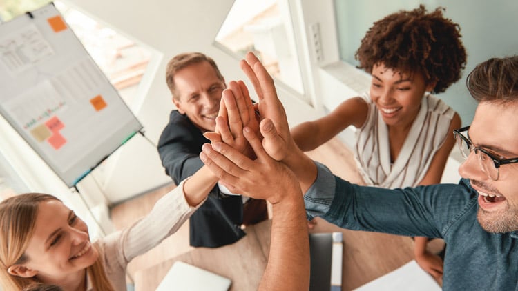 well-done-business-people-giving-each-other-highfive-smiling-while-working-together
